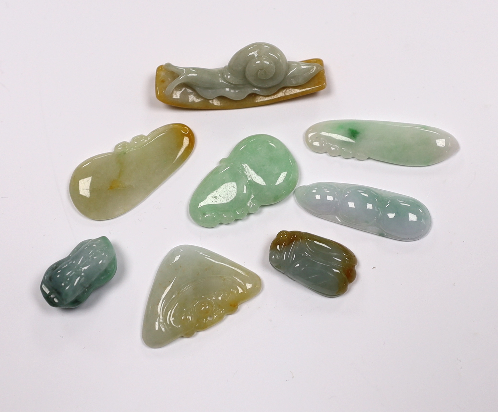 Eight various Chinese carved jadeite pendants